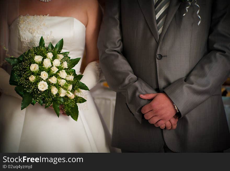 Groom and fiancee with a bouquet cost alongside