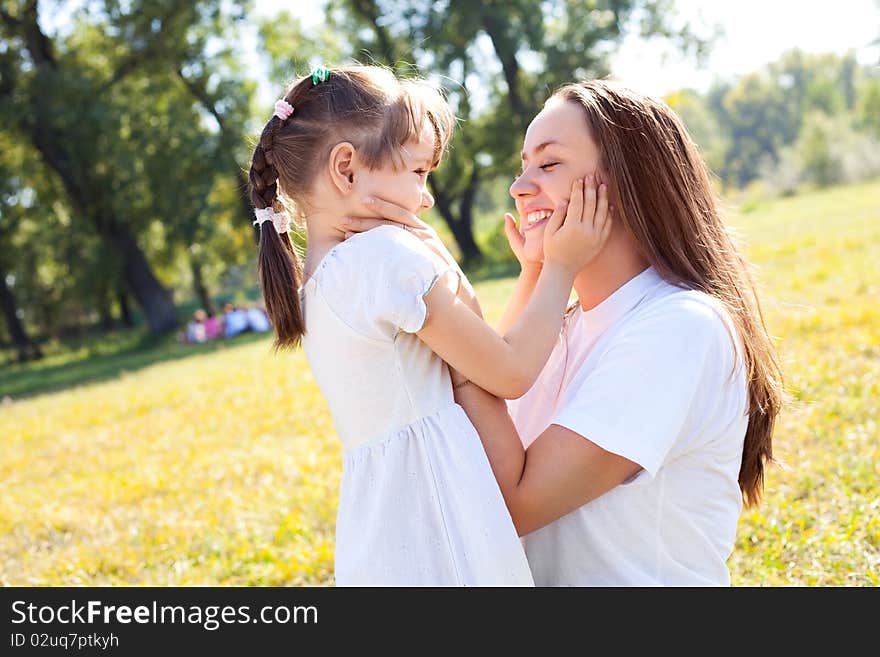 Beautiful young mother and her daughter in the park on a sunny autumn day. Beautiful young mother and her daughter in the park on a sunny autumn day