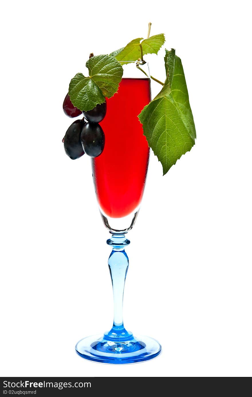 Red wine in glass with grapes. Isolated on white