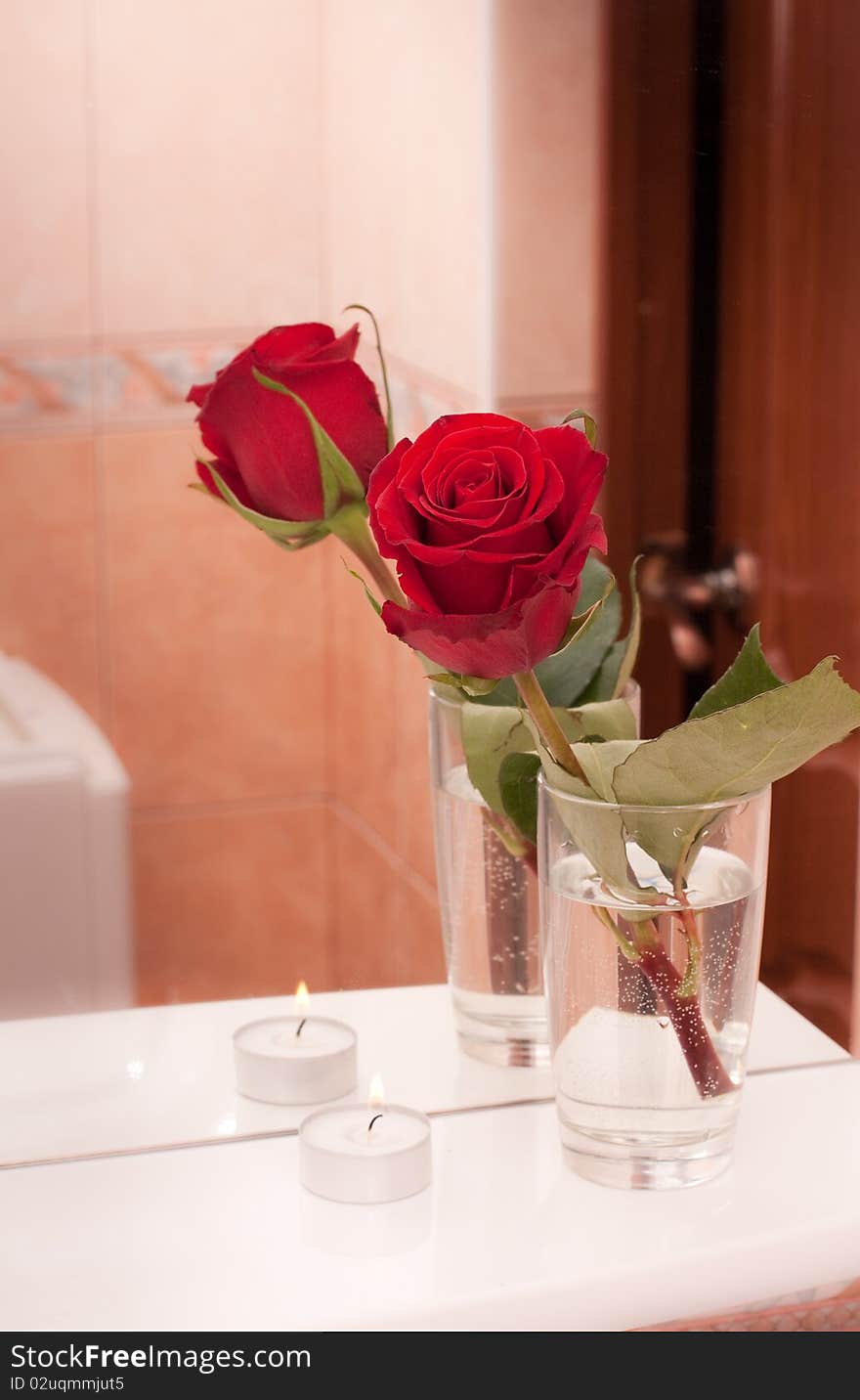 Rose with candle on mirror shelf