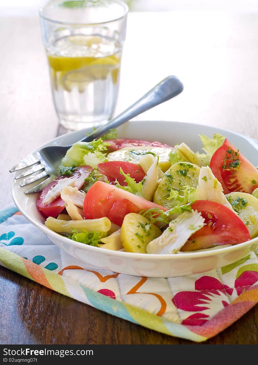 Salad from potatoes, lettuce, tomatoes and beans in bowl