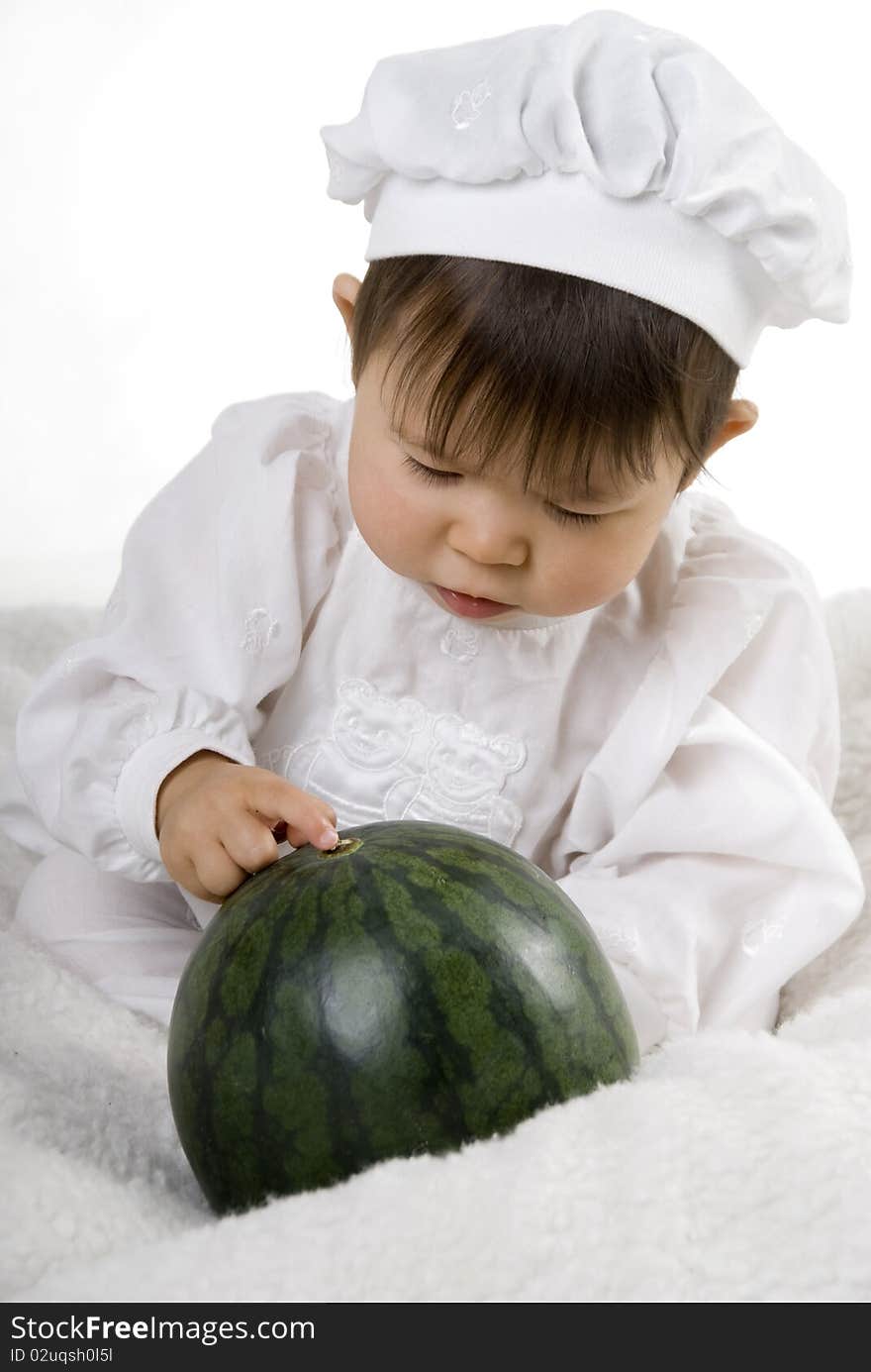 Little girl in the cook costume sitting with watermelon. Little girl in the cook costume sitting with watermelon