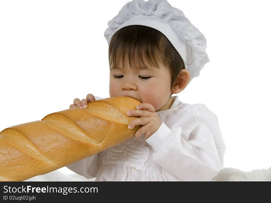 Baby in cook dress eating baguette and holding bread with hand. Baby in cook dress eating baguette and holding bread with hand