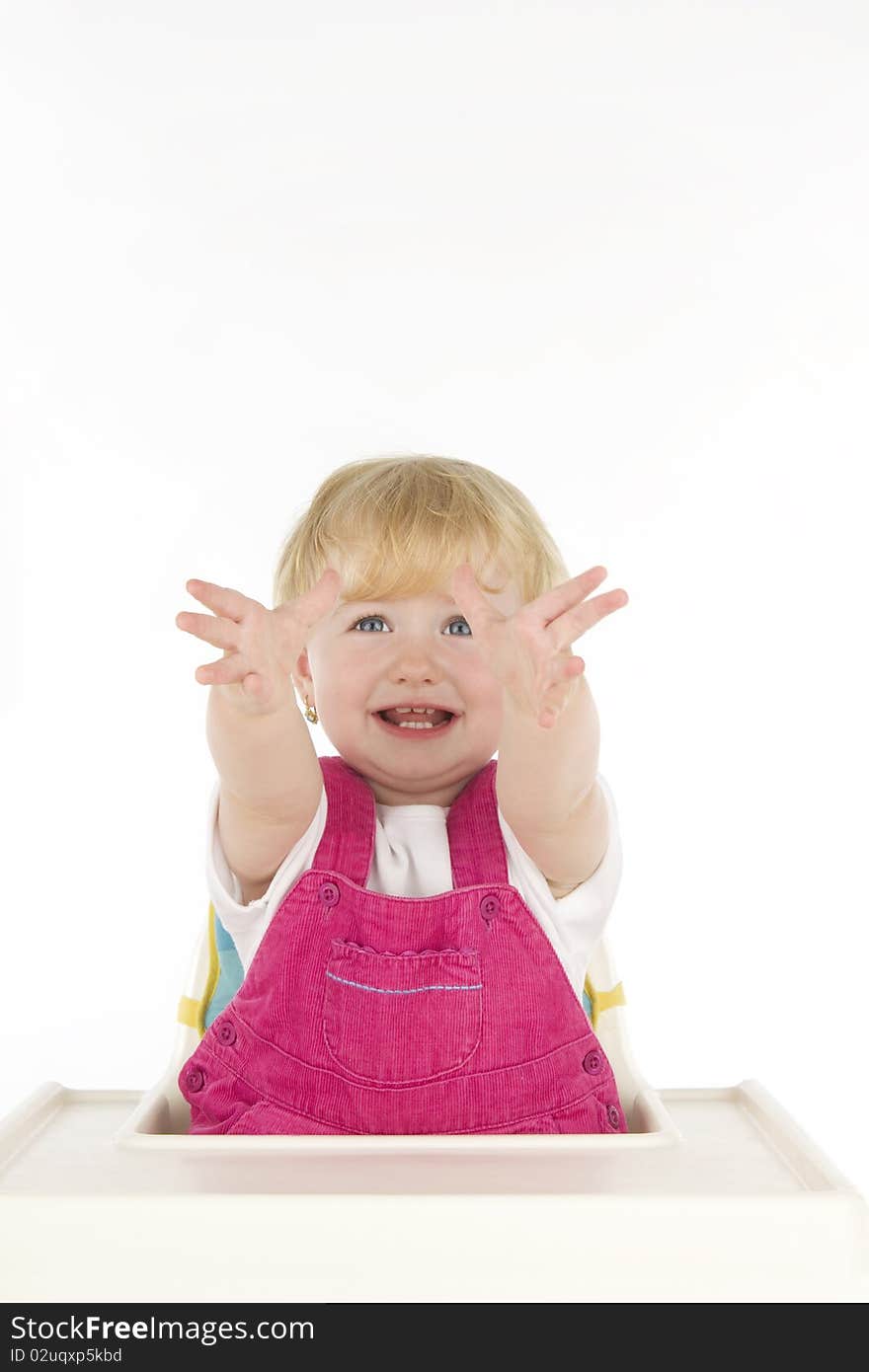 Infant sits in child's stool with outspreads hands in before, on white background. Infant sits in child's stool with outspreads hands in before, on white background.