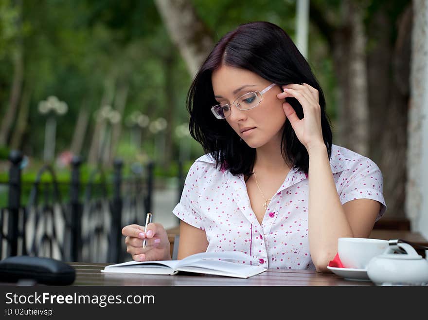 Young beautiful student girl with notepad in the cafe. Young beautiful student girl with notepad in the cafe