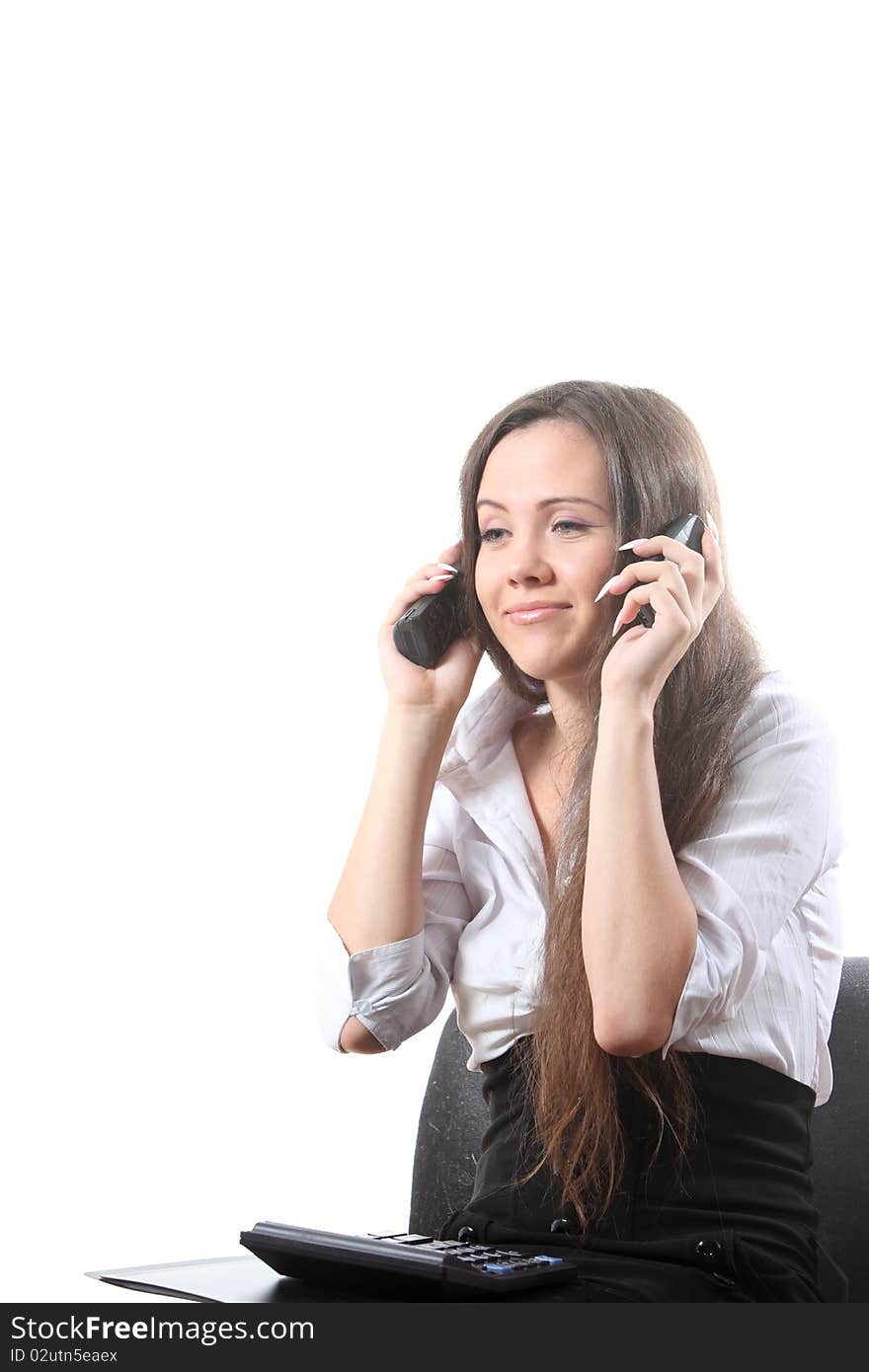 Businesswoman with a file and calculator speak by two phones. Businesswoman with a file and calculator speak by two phones