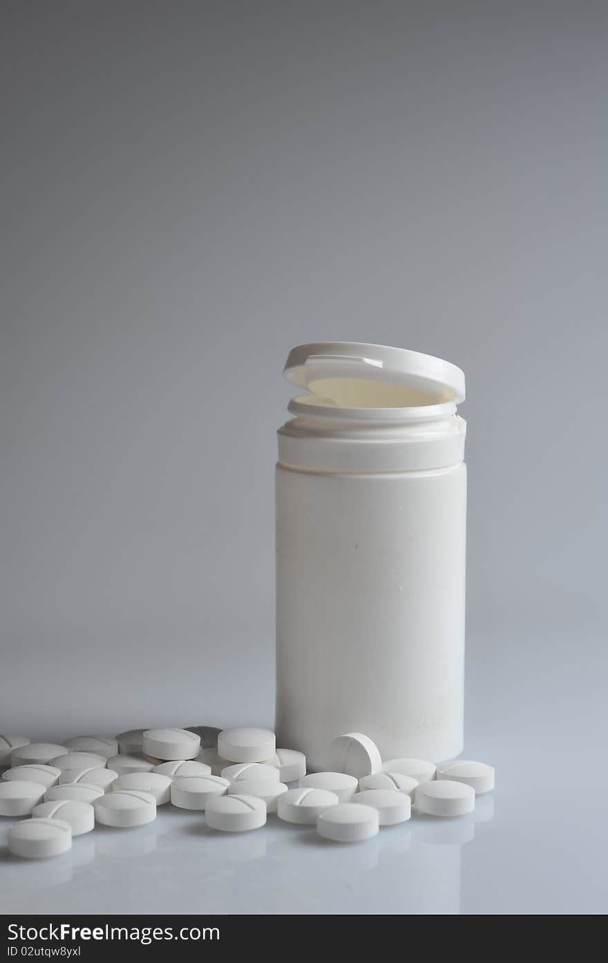 Open   prescription bottles  and white tablets  scattered on  table