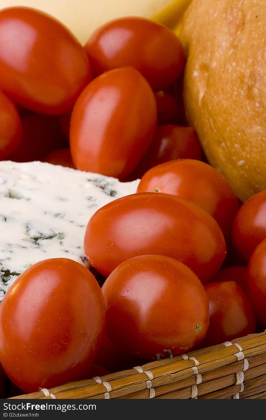 Slice of the Danish blue cheese with a mould among tomatoes.