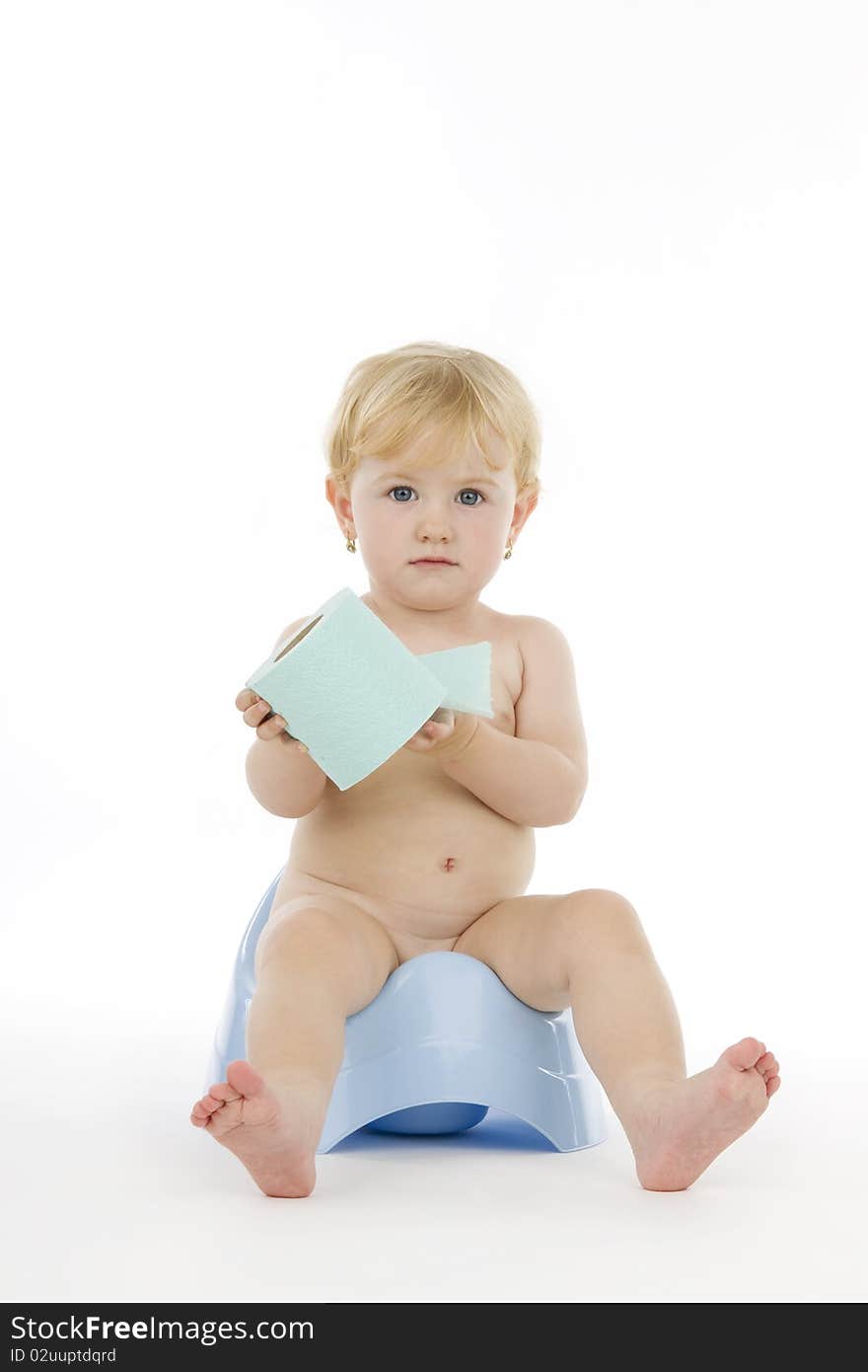 Infant on chamber and toilet paper, on white background.