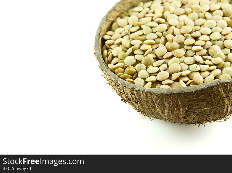 Lentils in a coconut shell bowl isolated on white background