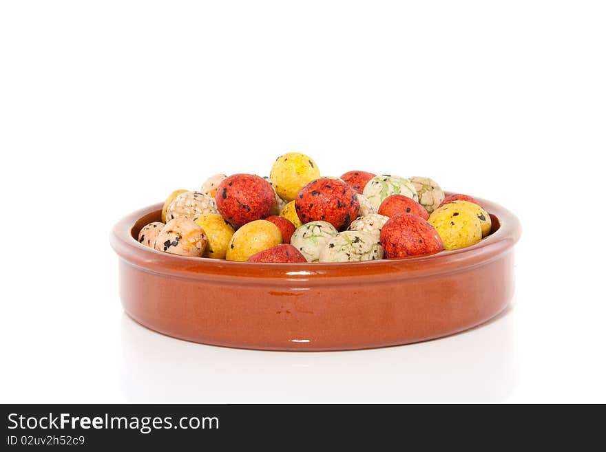 Japanese and sesame snacking crackers in a terracotta brown bowl isolated over white. Japanese and sesame snacking crackers in a terracotta brown bowl isolated over white