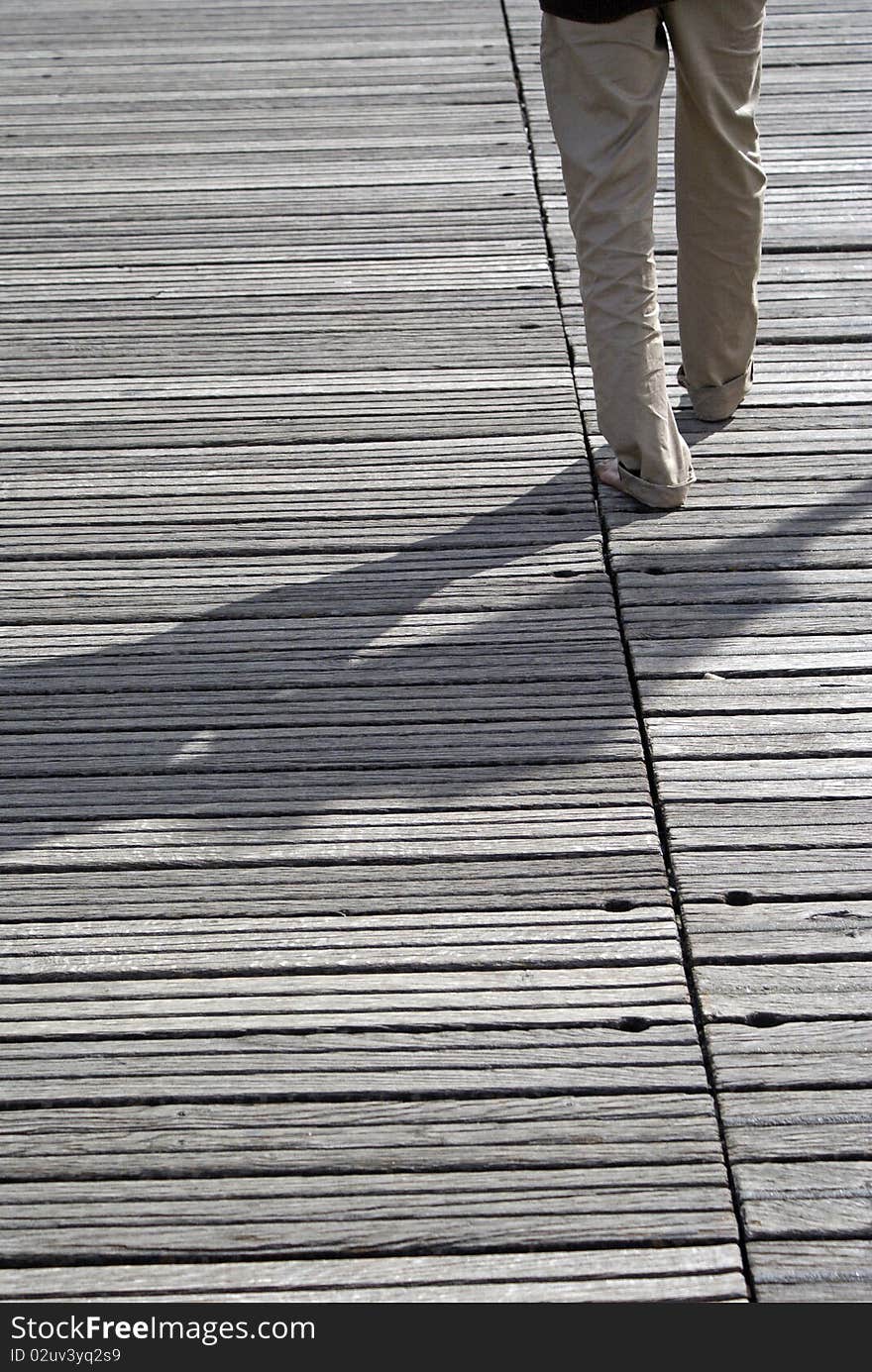 A man walking on a wood floor. A man walking on a wood floor