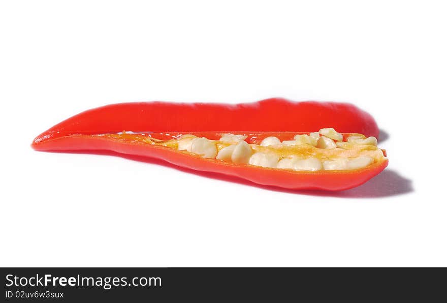 Sliced, red chili pepper isolated on a white background. Shallow depth of field with the nearest half of the chili in focus. Sliced, red chili pepper isolated on a white background. Shallow depth of field with the nearest half of the chili in focus.