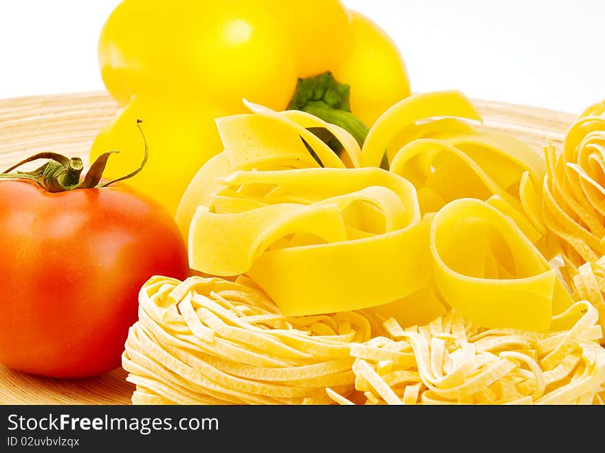 Raw Italian pasta on plate, tomato and pepper