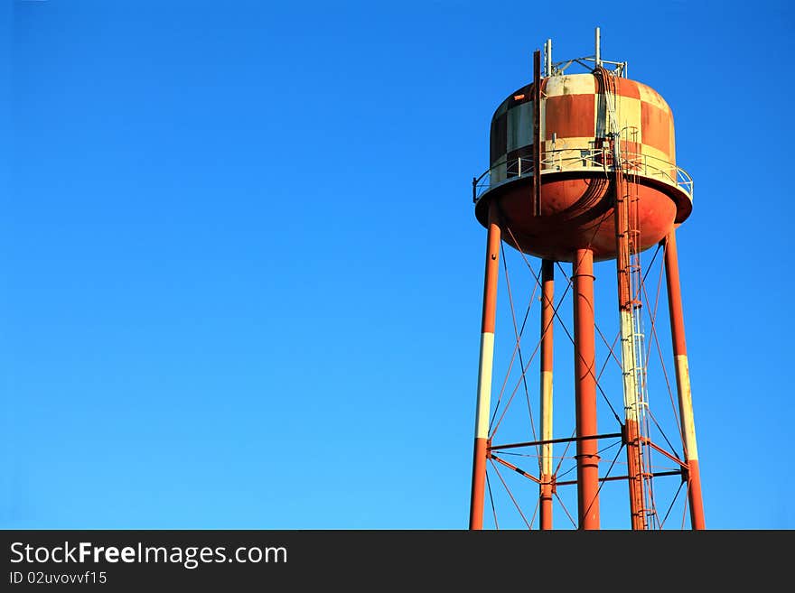 A red and white checkered water tower in rural America