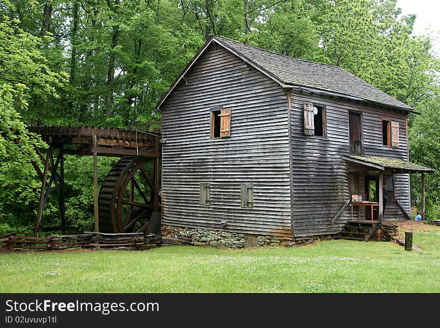 Old rustic gristmill nestled in the back hills of South Carolina surrounded by lush green trees. Old rustic gristmill nestled in the back hills of South Carolina surrounded by lush green trees