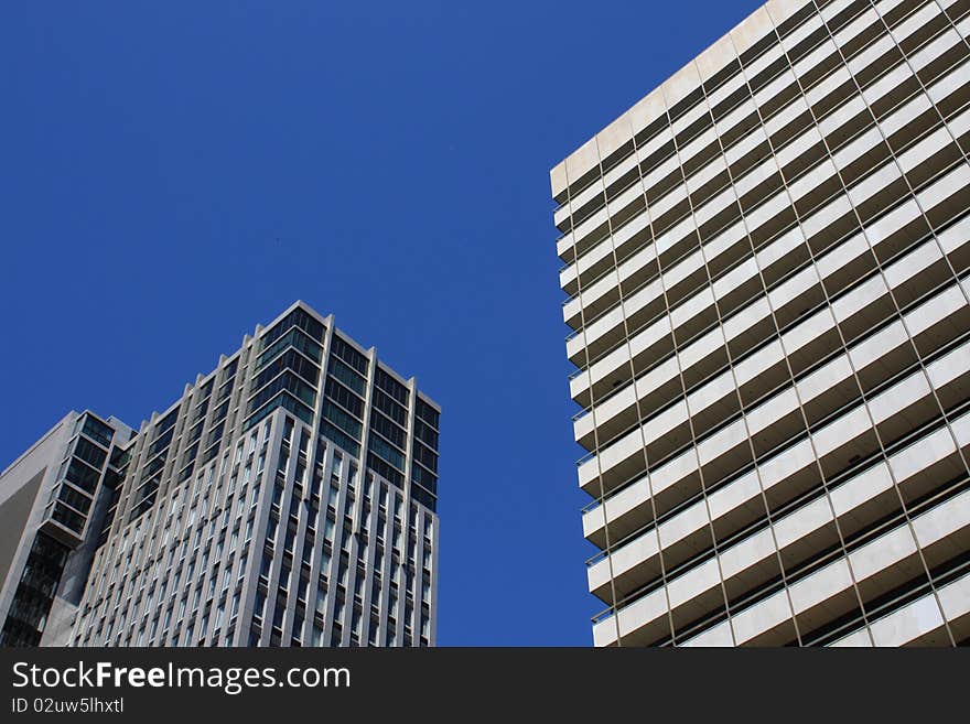 Two modern buildings against a blue sky