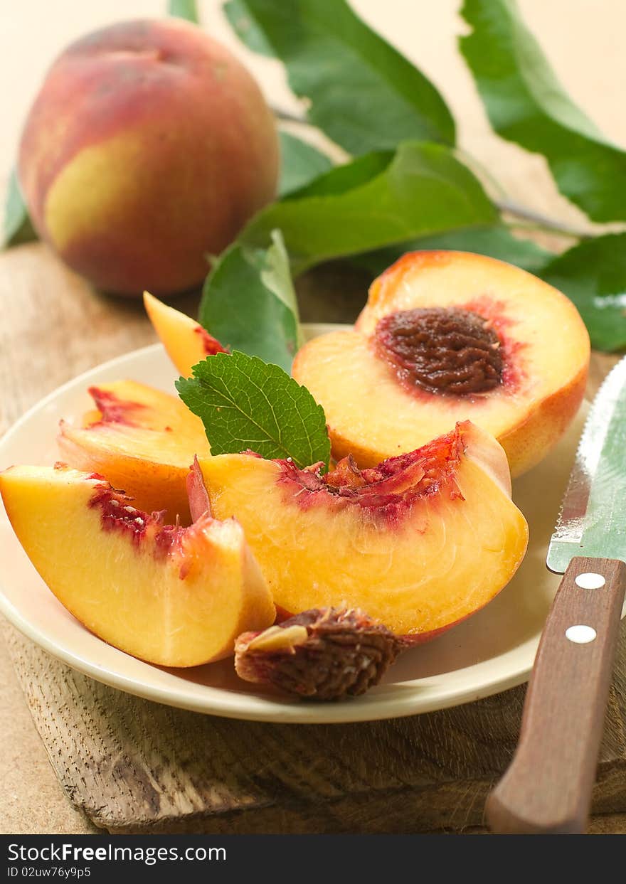 Fresh peaches on plate with knife