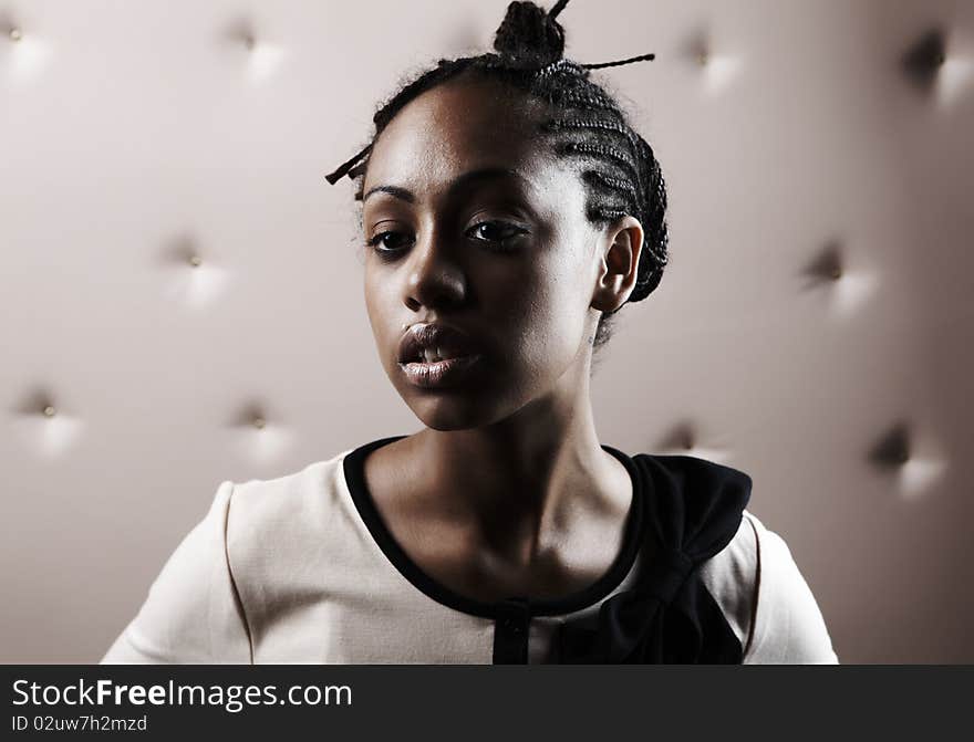 Close-up portrait of Beautiful African woman pose on a beige leather background.