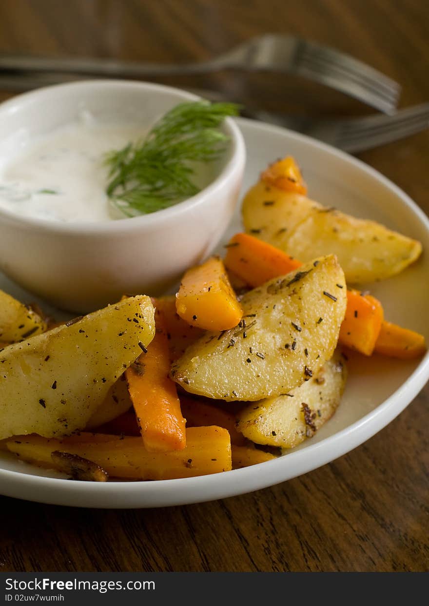 Roasted garlic potatoes and carrots with seasalt and sauce. Roasted garlic potatoes and carrots with seasalt and sauce