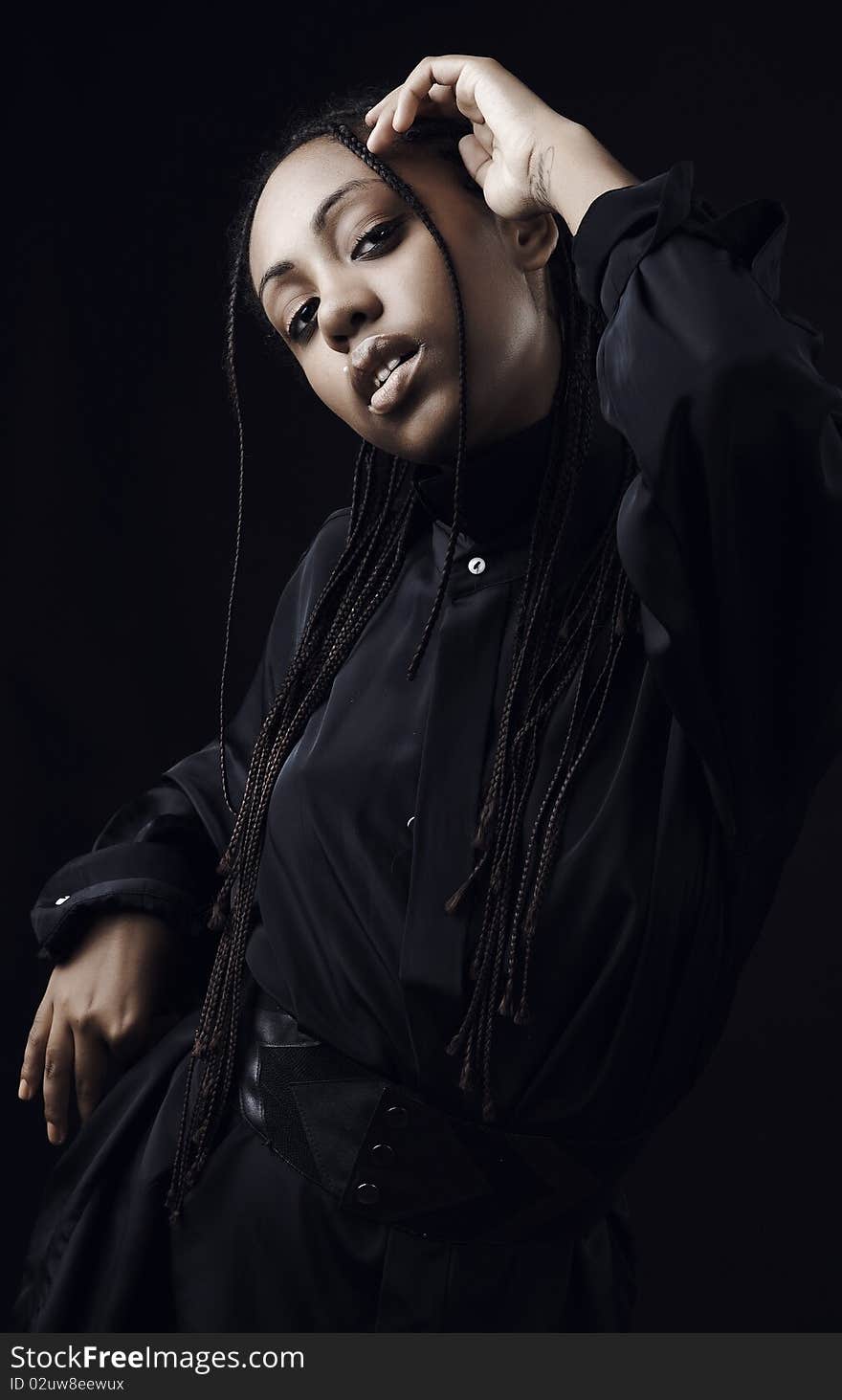 Portrait of a beautiful young black woman posing in black background.