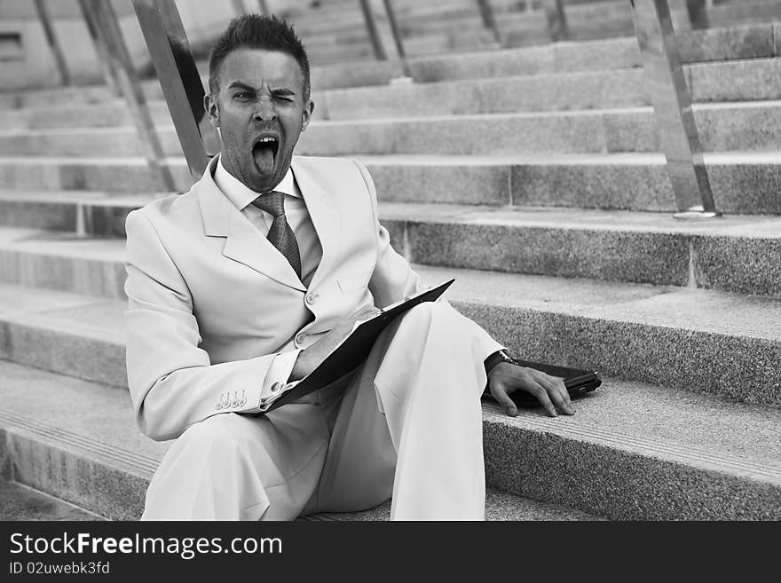 Handsome business man on the stairs reviewing his notes. Handsome business man on the stairs reviewing his notes