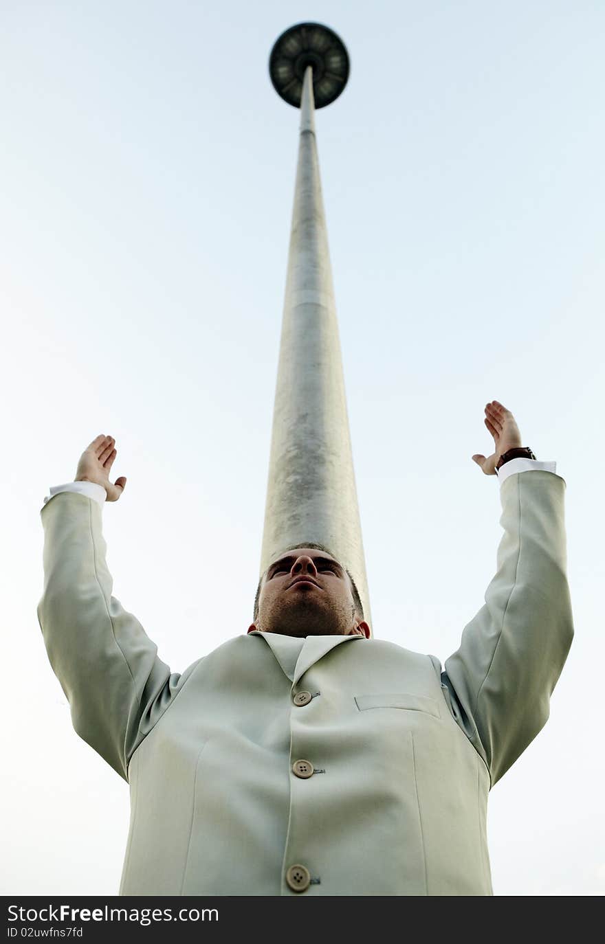 Vertical photo of man against a column leaving in the sky