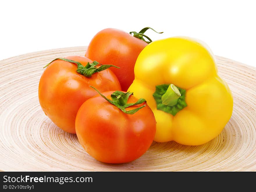 Tomatoes and pepper on wooden plate. Tomatoes and pepper on wooden plate