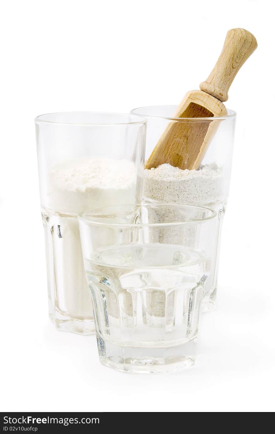 Glass of water, wheat and rye flour in glasses ready for mixing with wooden spoon. Glass of water, wheat and rye flour in glasses ready for mixing with wooden spoon