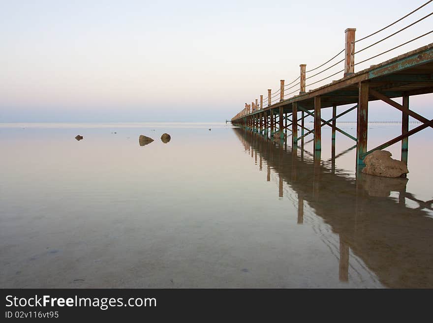 Bridge stretching out into vast ocean