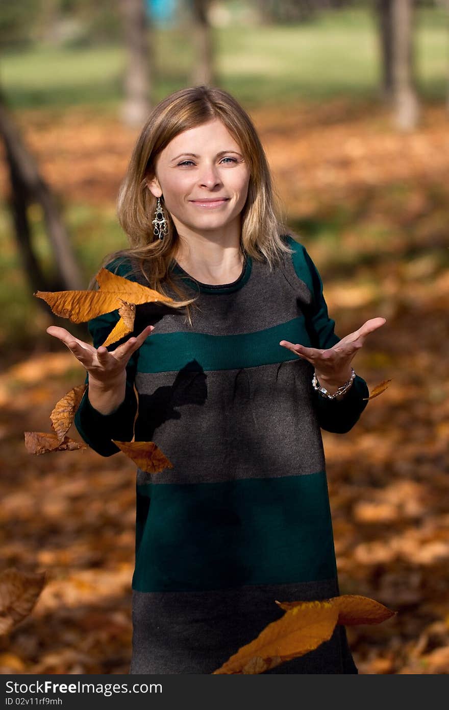 Playful beautiful blonde woman in autumn scenery. Playful beautiful blonde woman in autumn scenery