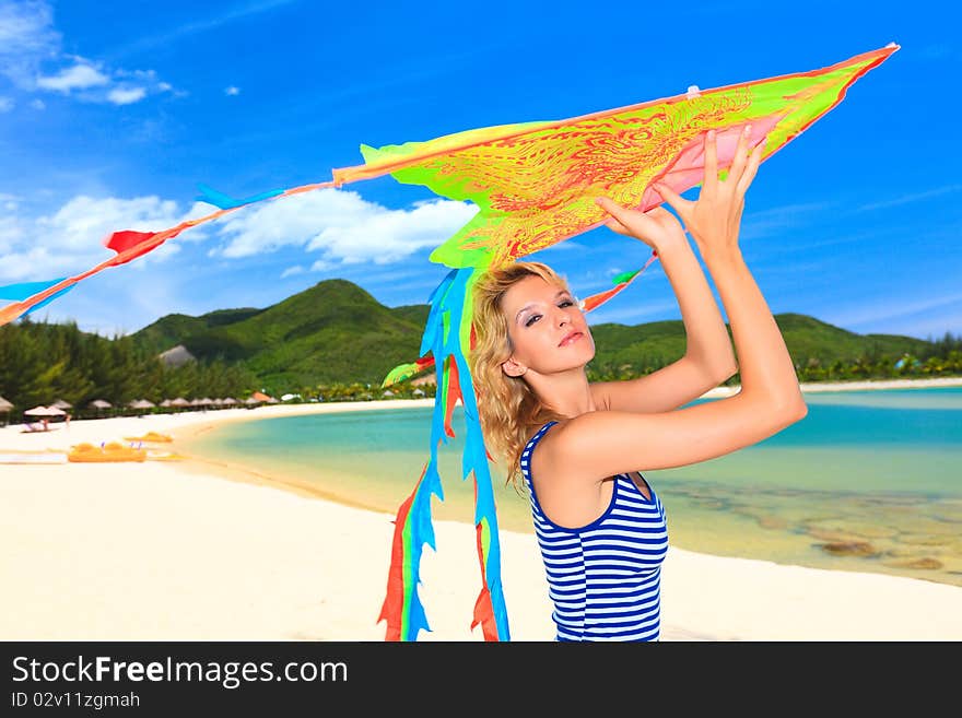 Young woman with kite on the beach