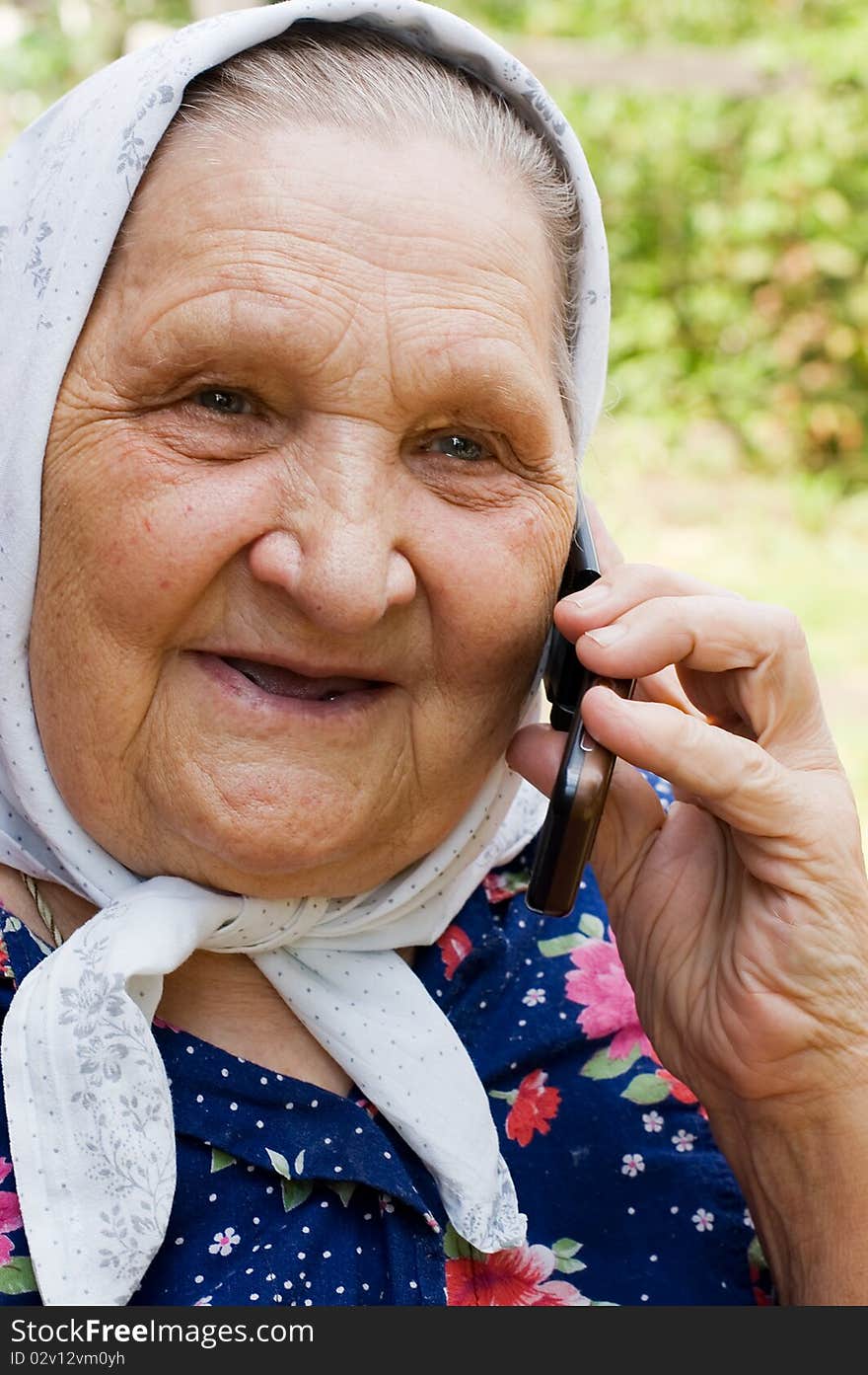 Grandmother talking with a phone close up