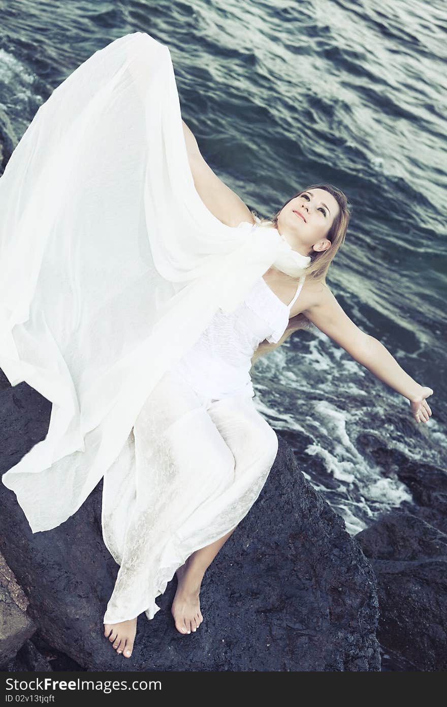 Young beautiful woman posing near the ocean. Young beautiful woman posing near the ocean