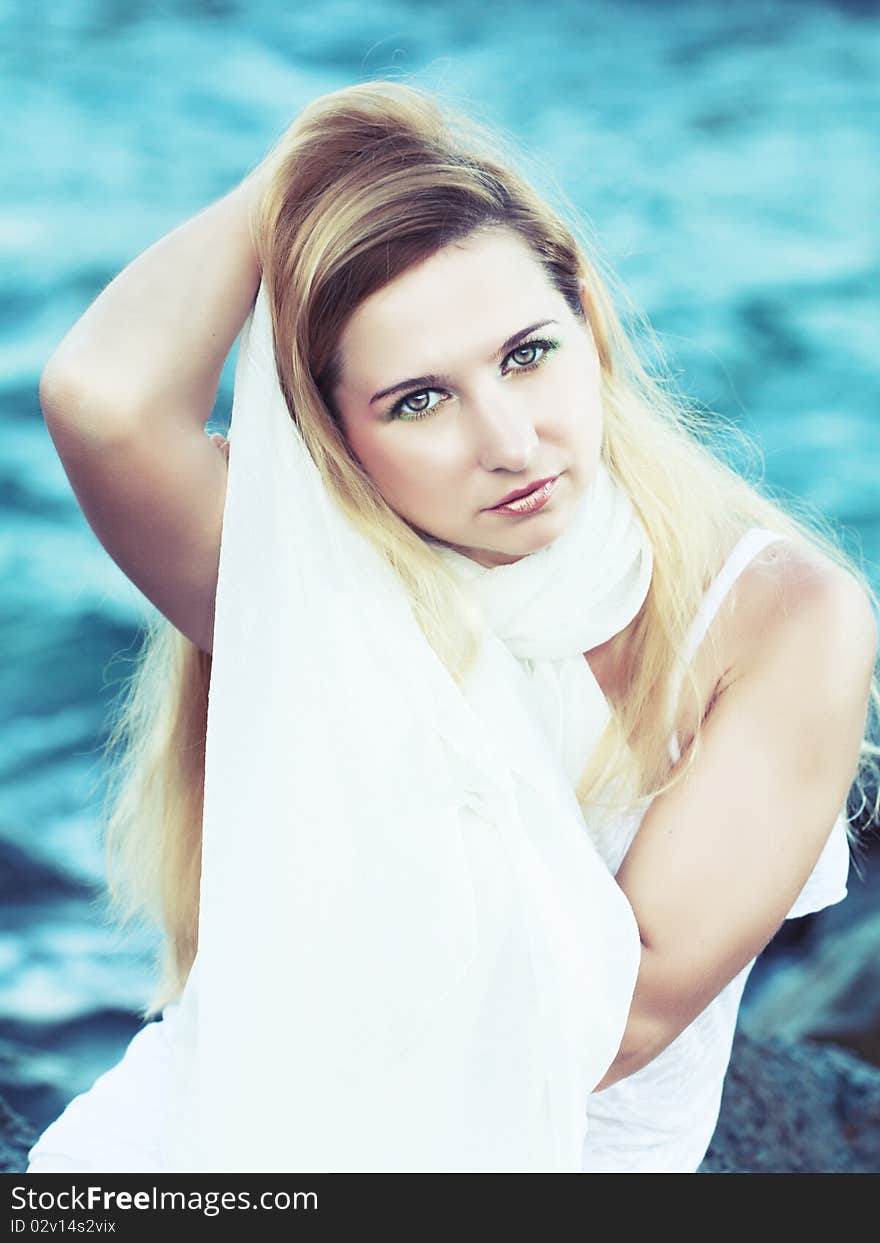 Young beautiful woman posing near the ocean. Young beautiful woman posing near the ocean