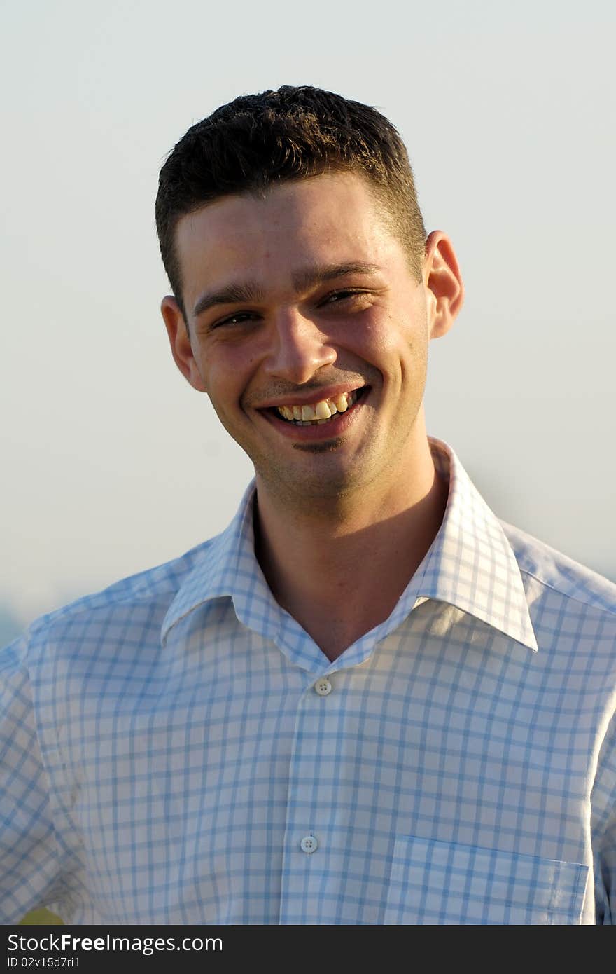 A young happy man is smiling. The man is looking at the camera. A young happy man is smiling. The man is looking at the camera.