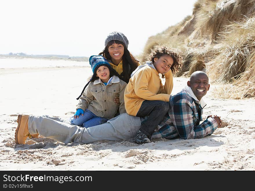 Family Sitting On Winter Beach