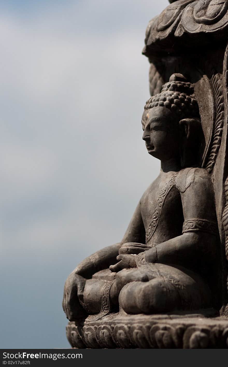 Buddha sitting in lotus pose, clouds in the background. Buddha sitting in lotus pose, clouds in the background