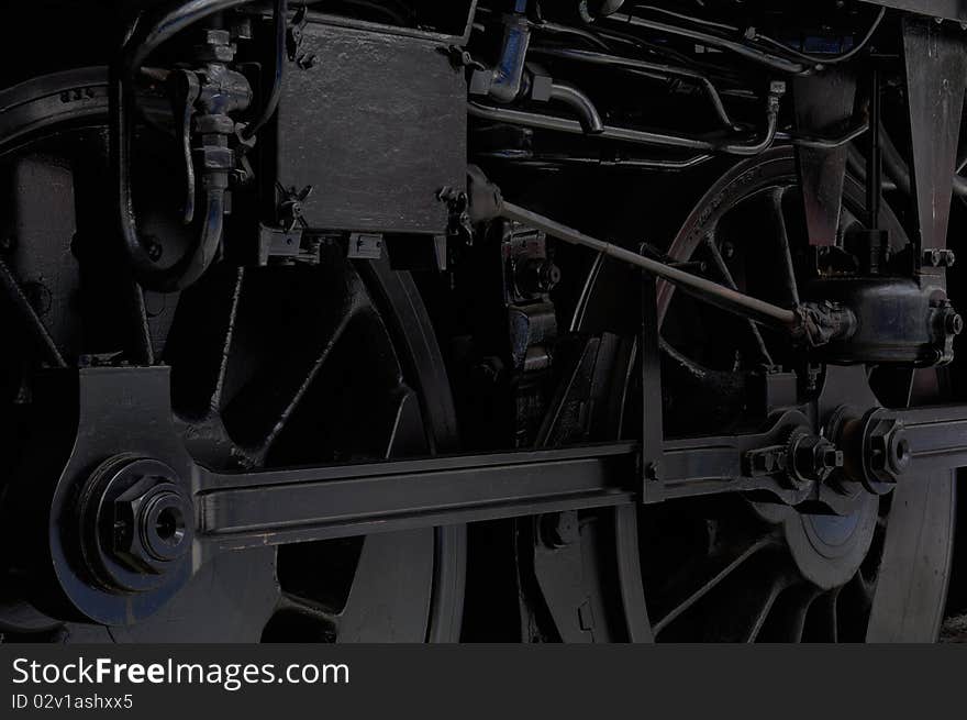 Lowkey shot of the wheels of a black vintage locomotive. Lowkey shot of the wheels of a black vintage locomotive