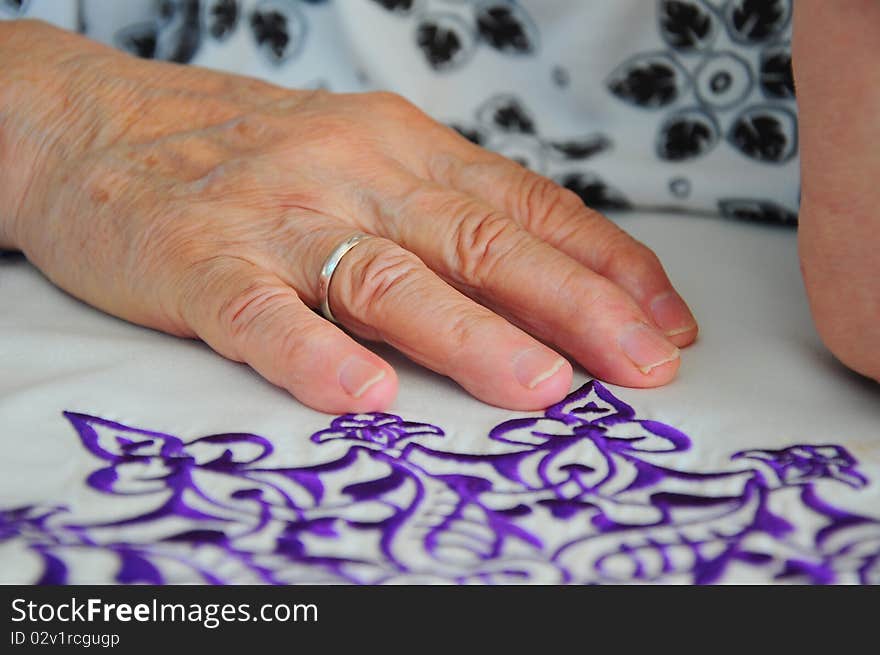 A wrinkled hand on table