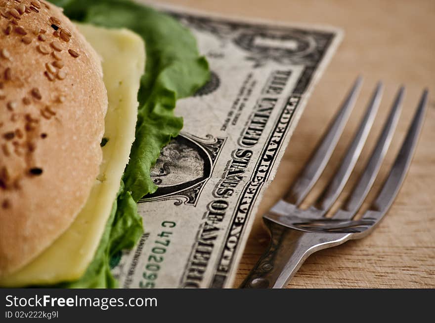 US dollars in a hamburger bun, close-up. US dollars in a hamburger bun, close-up