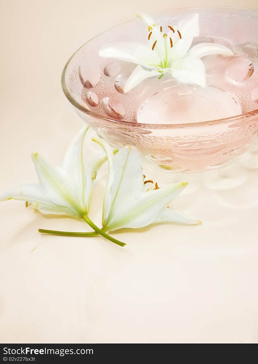 Spa bowl with pink water with lily flowers. Spa bowl with pink water with lily flowers