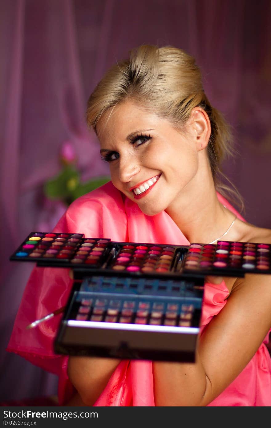 Beautiful girl holding a set of colored lipsticks for make-up. Beautiful girl holding a set of colored lipsticks for make-up