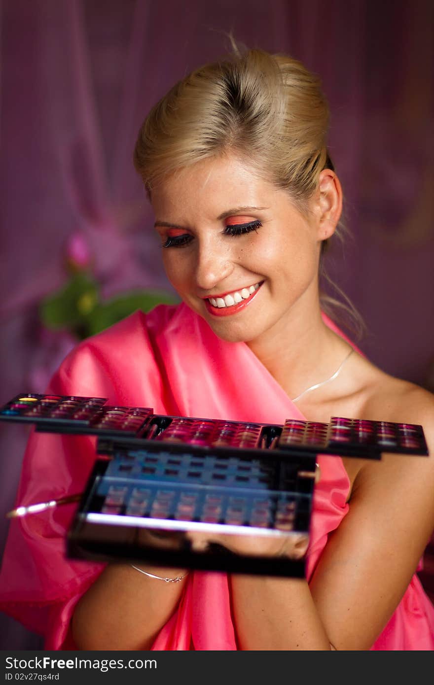 Beautiful girl holding a set of colored lipsticks for make-up. Beautiful girl holding a set of colored lipsticks for make-up