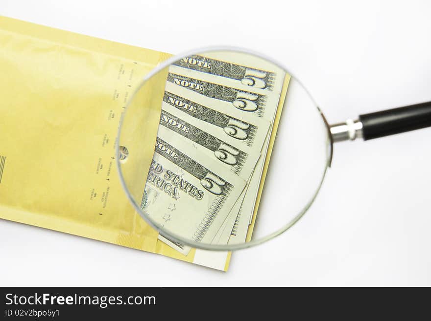 Dollars in the envelope with magnifying glass isolated on white background