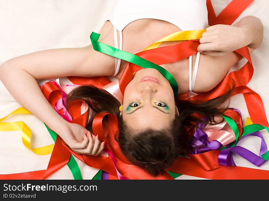 girl with colourful ribbons in studio on red background. girl with colourful ribbons in studio on red background