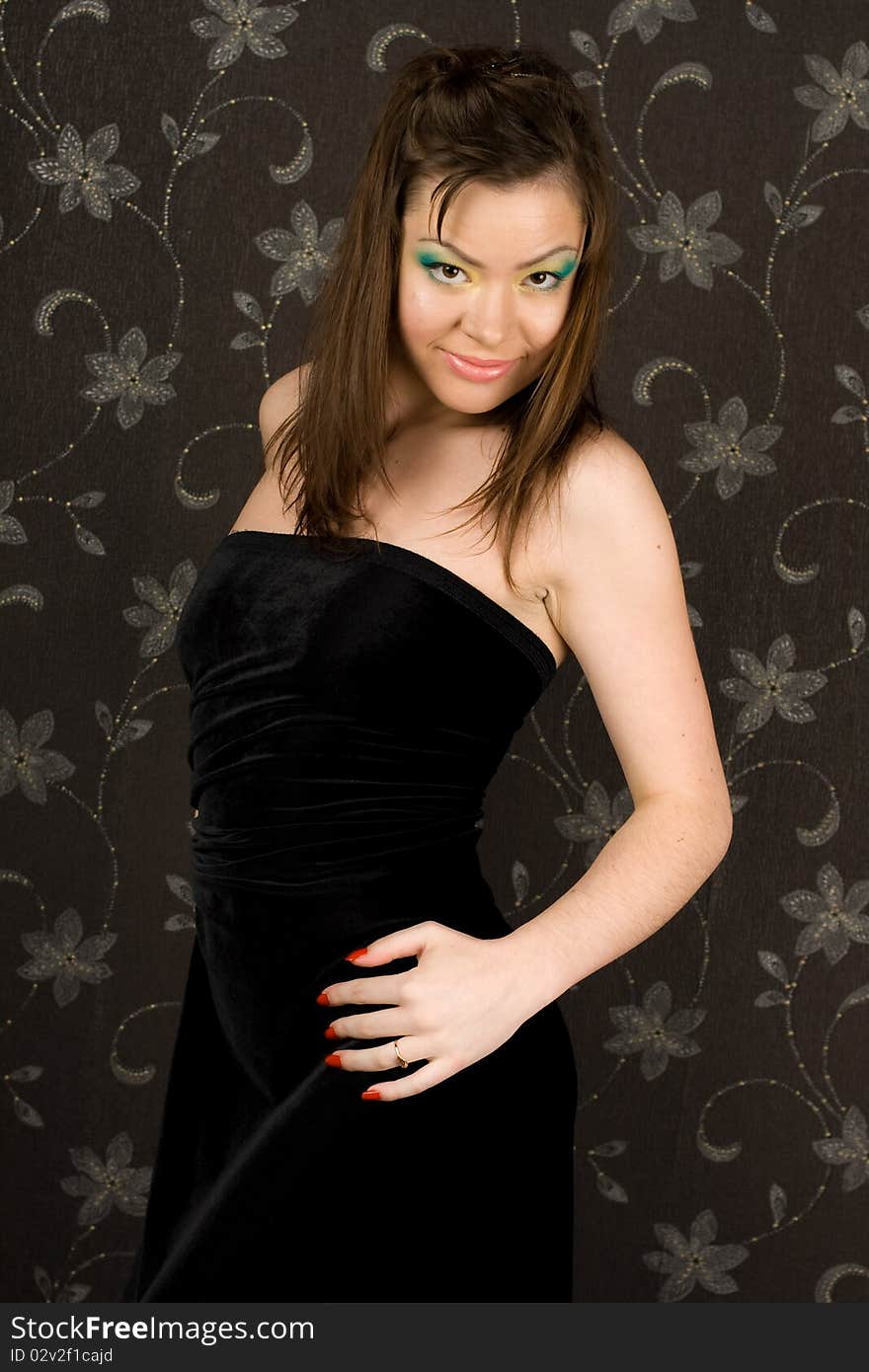 A girl in a black evening dress on a black background. The girl's eyes - bright yellow and green. A girl in a black evening dress on a black background. The girl's eyes - bright yellow and green