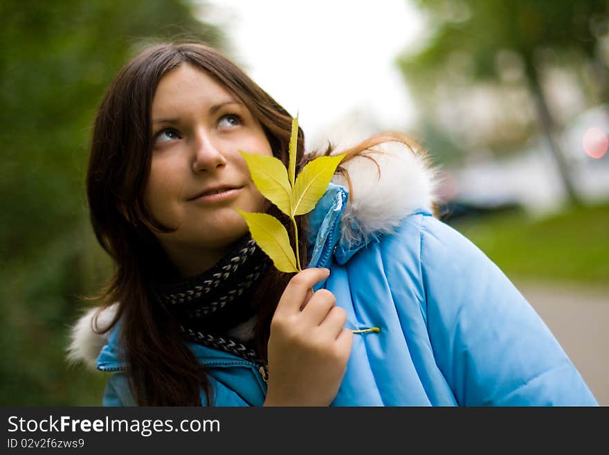 Portrai of beautiful smiling young girl with yellow dry leaves in fall park. Portrai of beautiful smiling young girl with yellow dry leaves in fall park