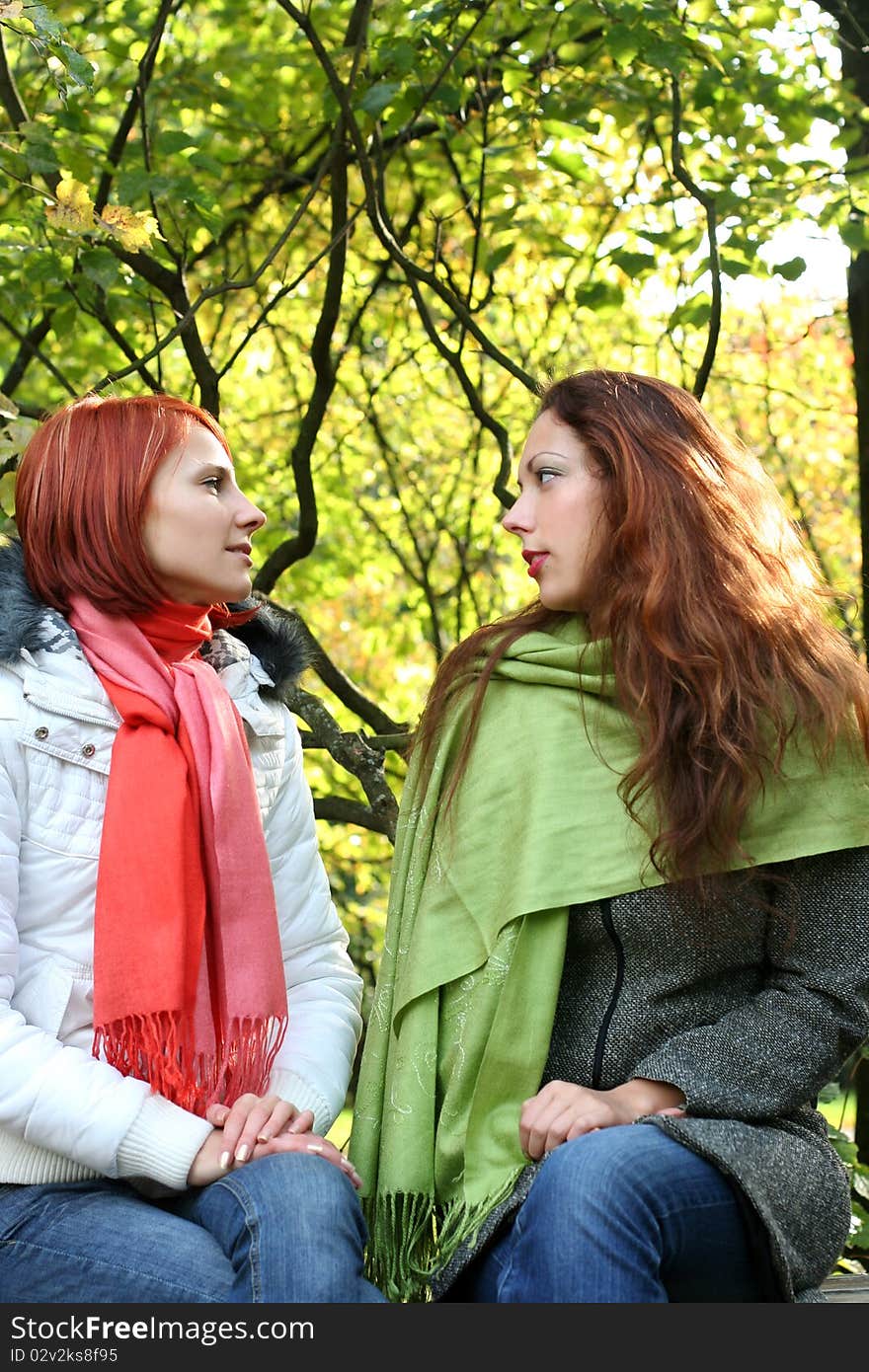 Two young girls relaxing in autumn park. Two young girls relaxing in autumn park