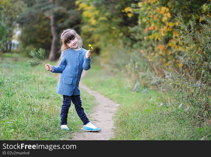 Adorable small girl in the autumn forest